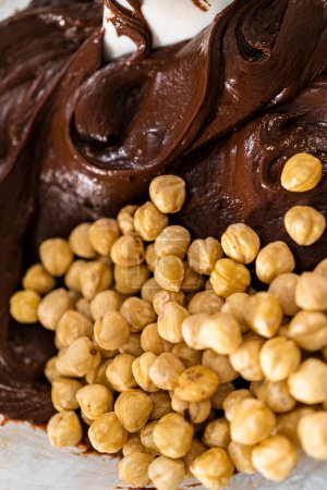 Téléchargez les photos : Faire fondre les pépites de chocolat et d'autres ingrédients dans un bol de mélange en verre sur de l'eau bouillante pour préparer le caramel au chocolat aux noisettes. - en image libre de droit