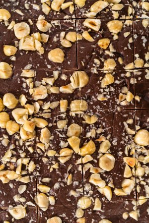 Téléchargez les photos : Marquage du caramel aux noisettes au chocolat à l'aide d'un coupe-pâte à roulettes pour couper en petits morceaux carrés. - en image libre de droit