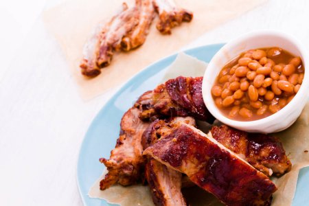 Photo for Baby back ribs on the plate with baked beand. - Royalty Free Image