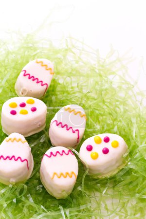 Foto de Pasteles petit huevo de Pascua hechos con capas de pastel de vainilla y tarta, mermelada de frambuesa
. - Imagen libre de derechos
