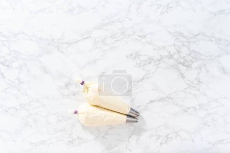 Photo for Flat lay. Piping bags with jumbo metal piping tips filled in with Jumbo metal piping tip for cupcake frosting. - Royalty Free Image