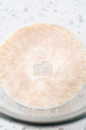 Foto de Activación de la levadura seca en un recipiente mezclador de vidrio para hornear bañadores naan. - Imagen libre de derechos