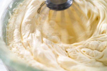 Photo for Whipping white ganache in kitchen mixer to make the white chocolate ganache frosting. - Royalty Free Image