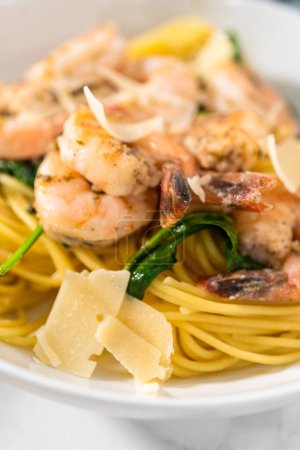 Téléchargez les photos : Serving garlic shrimp pasta with spinach in white ceramic bowls. - en image libre de droit