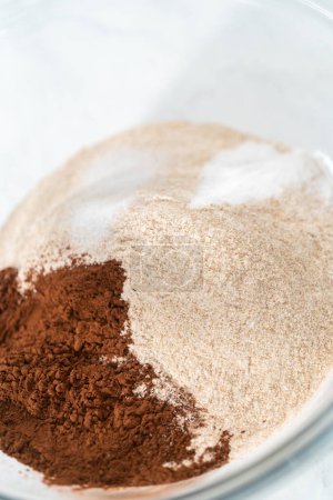 Photo for Mixing ingredients in a glass mixing bowl to bake chocolate graham crackers. - Royalty Free Image
