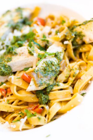Photo for Fresh fettucini with chicken, red peppers, and basil pesto. - Royalty Free Image