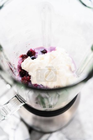 Photo for Mixing ingredients in kitchen blender to prepare mixed berry boba smoothie. - Royalty Free Image