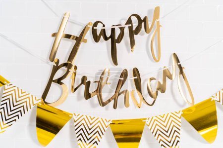 Photo for Paper Happy Birthday gold paper banner in the kitchen. - Royalty Free Image