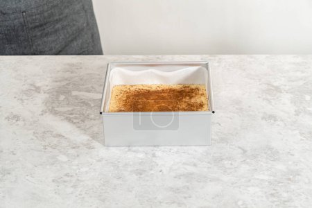 Téléchargez les photos : Caramel au lait de poule fraîchement fait maison dans un moule à gâteau au fromage carré doublé de papier parchemin. - en image libre de droit
