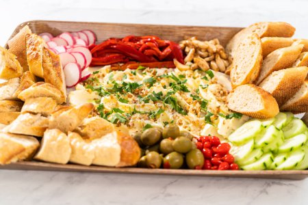 Photo for A large vegetarian party butter board with fresh and pickled vegetables and sliced french baguette for a party. - Royalty Free Image