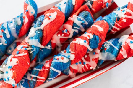 Photo for Patriotic cinnamon twists drizzled with a white glaze and decorated with star sprinkles. - Royalty Free Image