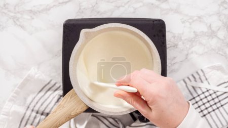 Téléchargez les photos : Pose plate. Pas à pas. Préparation de ganache au chocolat dans une petite casserole. - en image libre de droit