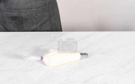 Téléchargez les photos : Homemade whipped cream in a piping bag with a metal tip. - en image libre de droit