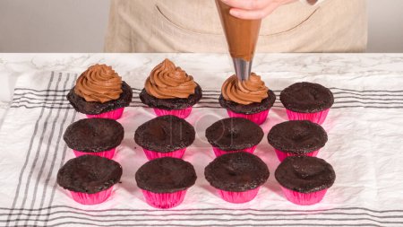 Foto de Step by step. Piping chocolate ganache frosting on top of chocolate cupcakes. - Imagen libre de derechos
