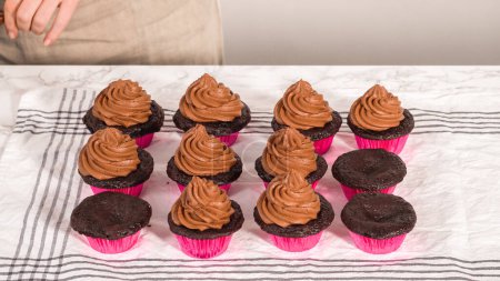 Téléchargez les photos : Step by step. Piping chocolate ganache frosting on top of chocolate cupcakes. - en image libre de droit