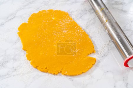 Photo for Lemon wedge cookies with lemon glaze. Rolling cookie dough with an adjustable rolling pin and cutting out cookies with cookie cutters to bake lemon wedge cookies with lemon glaze. - Royalty Free Image