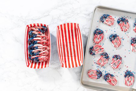 Foto de Flat lay. American flag. Red, white, and blue chocolate-covered pretzel twists. - Imagen libre de derechos