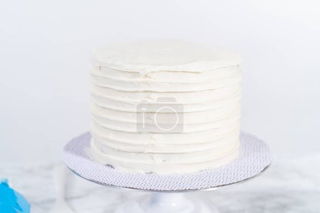 Photo for Frosting chocolate cake with vanilla buttercream frosting. - Royalty Free Image