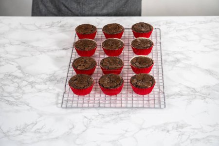Téléchargez les photos : Refroidissement de cupcakes à la menthe poivrée au chocolat fraîchement cuits sur un comptoir de cuisine. - en image libre de droit