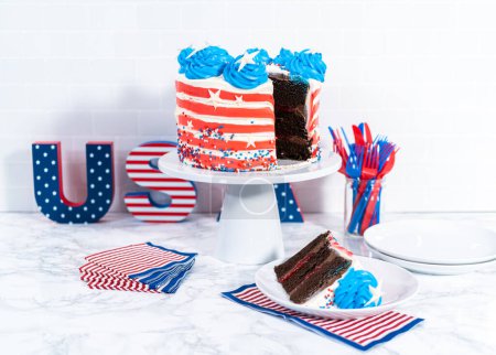 Photo for Slicing July 4th chocolate cake decorated with red, white, and blue buttercream frosting. - Royalty Free Image