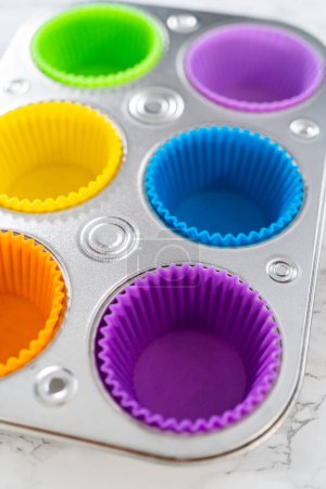Téléchargez les photos : Nouvelles doublures de cupcake en silicone de différentes couleurs sur le comptoir de la cuisine. - en image libre de droit