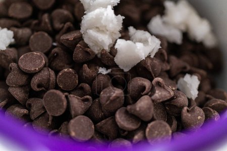 Téléchargez les photos : Fondre des pépites de chocolat dans un melting pot de bonbons pour faire du glaçage au chocolat pour biscuits sablés en forme de panda. - en image libre de droit