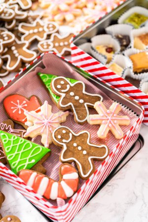 Foto de Embalaje de una variedad casera de galletas de caramelo y pan de jengibre para regalos de comida de Navidad en cajas de lata. - Imagen libre de derechos