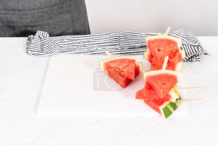 Téléchargez les photos : Trancher la pastèque rouge hachée pour préparer des pops chili lime pastèque. - en image libre de droit