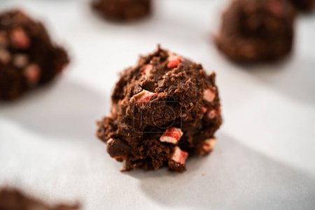 Téléchargez les photos : Ramasser la pâte à biscuits au chocolat avec une cuillère à pâte pour cuire des biscuits au chocolat avec des pépites de menthe poivrée. - en image libre de droit