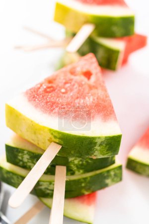 Photo for Slicing riped red watermelon to prepare chili lime watermelon pops. - Royalty Free Image