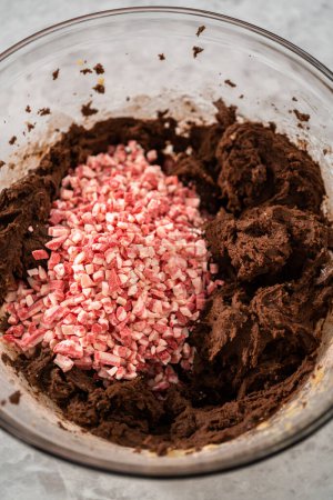 Photo for Folding in peppermint chocolate chips into a chocolate cookie dough to bake chocolate cookies with peppermint chips. - Royalty Free Image