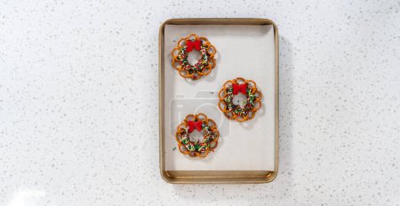 Photo for Flat lay. Removing a chocolate pretzel Christmas wreath from the parchment paper. - Royalty Free Image