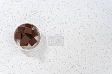 Téléchargez les photos : Pièces de caramel nature maison sur une plaque en céramique blanche. - en image libre de droit