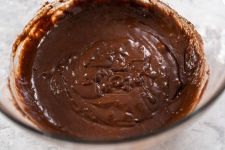 Téléchargez les photos : Mélanger les ingrédients dans un bol de mélange en verre avec un fouet mélangeur pour cuire des cupcakes aux fraises au chocolat. - en image libre de droit