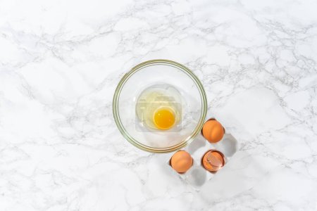 Téléchargez les photos : Mélanger les ingrédients humides dans un grand bol à mélanger en verre pour faire cuire mini pain de Pâques kulich. - en image libre de droit
