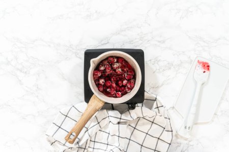 Photo for Flat lay. In a small saucepan, the measured ingredients come together - allowing the delicious Raspberry Cake Filling to simmer and infuse with delightful flavors. - Royalty Free Image