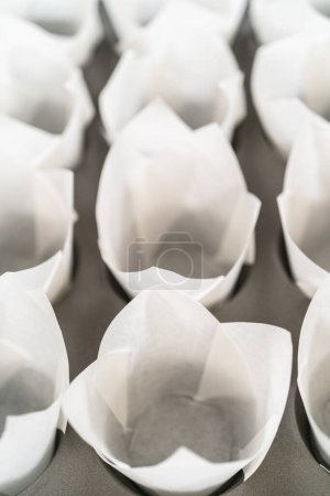 Foto de Forro de panecillo para hornear magdalenas con revestimientos de tulipán de papel para hornear cupcakes de canela sin levadura. - Imagen libre de derechos