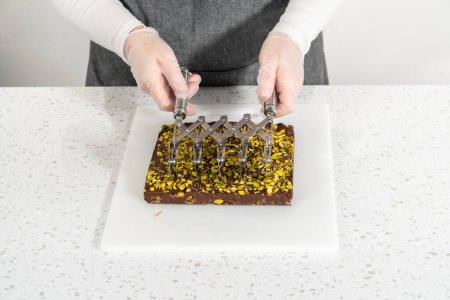 Photo for Scoring chocolate pistachio fudge into perfect squares for cutting. - Royalty Free Image