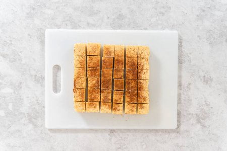 Photo for Flat lay. Homemade eggnog fudge pieces on a white cutting board. - Royalty Free Image