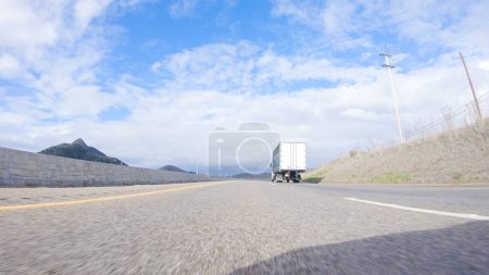 Foto de Santa Maria, California, USA-December 6, 2022-En un día de invierno crujiente, un automóvil cruza a lo largo de la icónica autopista 101 cerca de San Luis Obispo, California. El paisaje circundante es marrón y tenue - Imagen libre de derechos