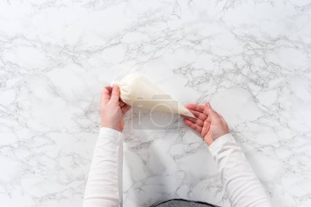 Photo for Flat lay. Homemade royal icing in piping bags ready to decorate sugar cookies on the kitchen counter. - Royalty Free Image