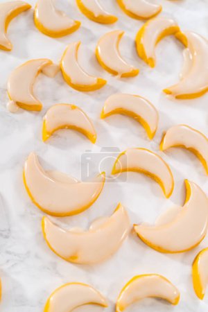 Foto de Galletas de cuña de limón con glaseado de limón. Sumergiendo galletas de limón en un glaseado de limón. - Imagen libre de derechos