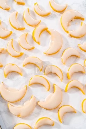 Photo for Lemon wedge cookies with lemon glaze. Dipping lemon cookies into a lemon glaze. - Royalty Free Image