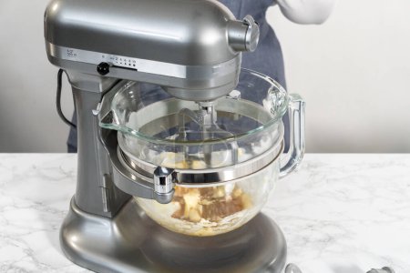 Foto de Mezclar los ingredientes en una batidora de pie de cocina para hornear galletas suaves de avena y pasas de uva. - Imagen libre de derechos