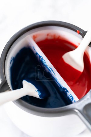Photo for Melting chocolate chips in a candy melting pot to make red, white, and blue chocolate-covered pretzel twists. - Royalty Free Image