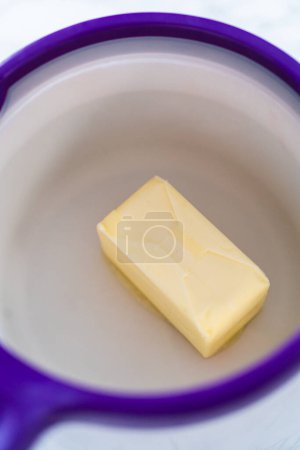 Téléchargez les photos : Bâton de fusion de beurre non salé dans un melting pot de bonbons. - en image libre de droit