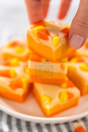 Téléchargez les photos : Bonbons faits maison morceaux carrés de caramel de maïs sur une plaque blanche. - en image libre de droit