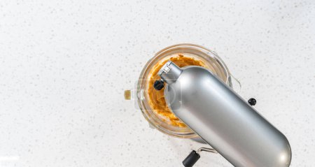 Téléchargez les photos : Flat lay. Whipping ingredients in a stand electric mixer to make dulce de leche buttercream frosting. - en image libre de droit