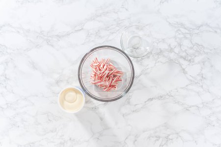 Téléchargez les photos : Flat lay. Measured ingredients in a glass mixing bowl to prepare peppermint buttercream frosting. - en image libre de droit