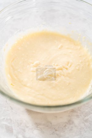 Photo for Mixing ingredients with a hand mixer in a large mixing bowl to make the cream cheese filling for carrot bundt cake. - Royalty Free Image